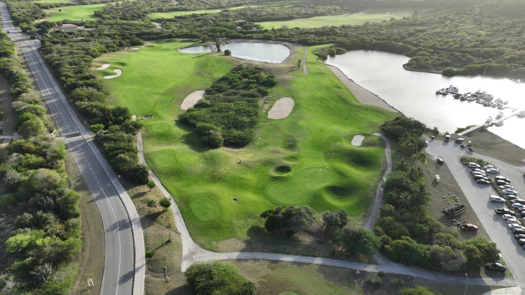 Lost or found something. Aerial view of Hole 6 and Hole 14 at Old Quarry Golf Course Curaçao, surrounded by water and native terrain