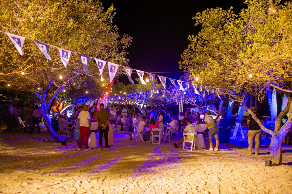 Guests serving themselves at illuminated beach buffet during a night event at Old Quarry Golf Course Curaçao