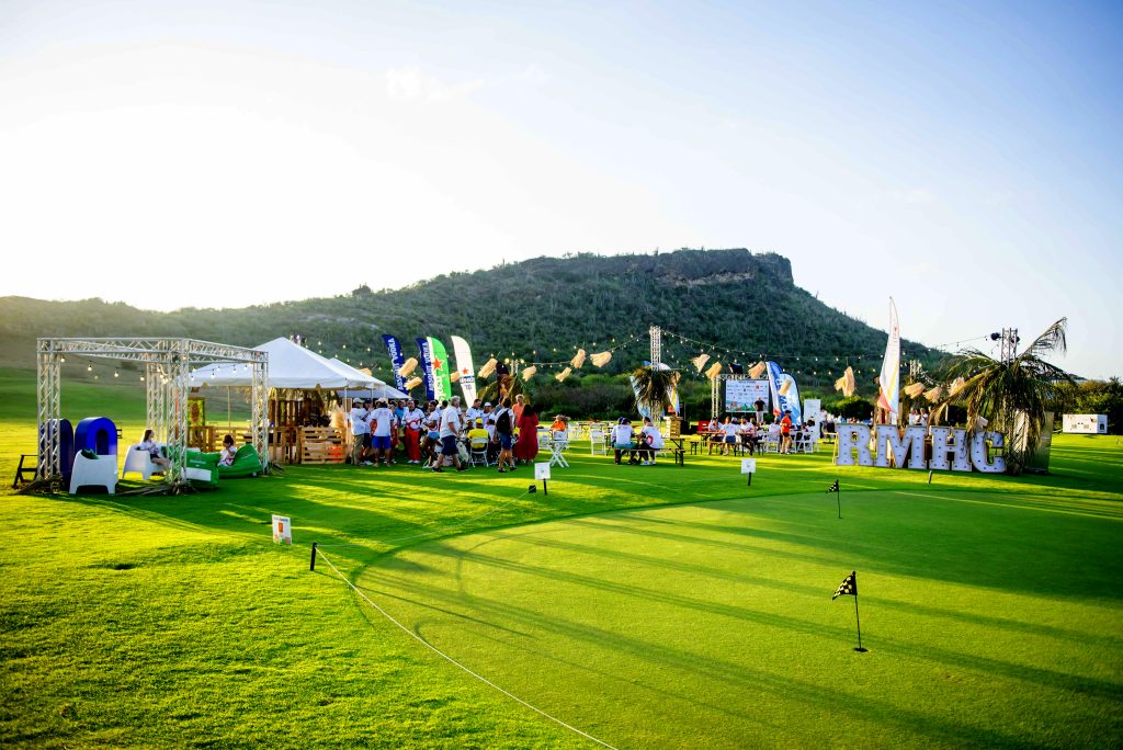 Outdoor golf event setup at Old Quarry Golf Course with RMHC signage, tents, and seating