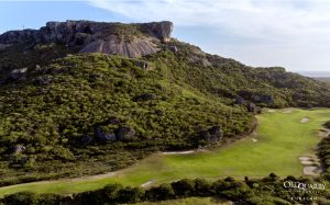 Aerial view of Hole 12 at Old Quarry Golf Course Curaçao, with a dramatic limestone cliff towering beside the fairway.