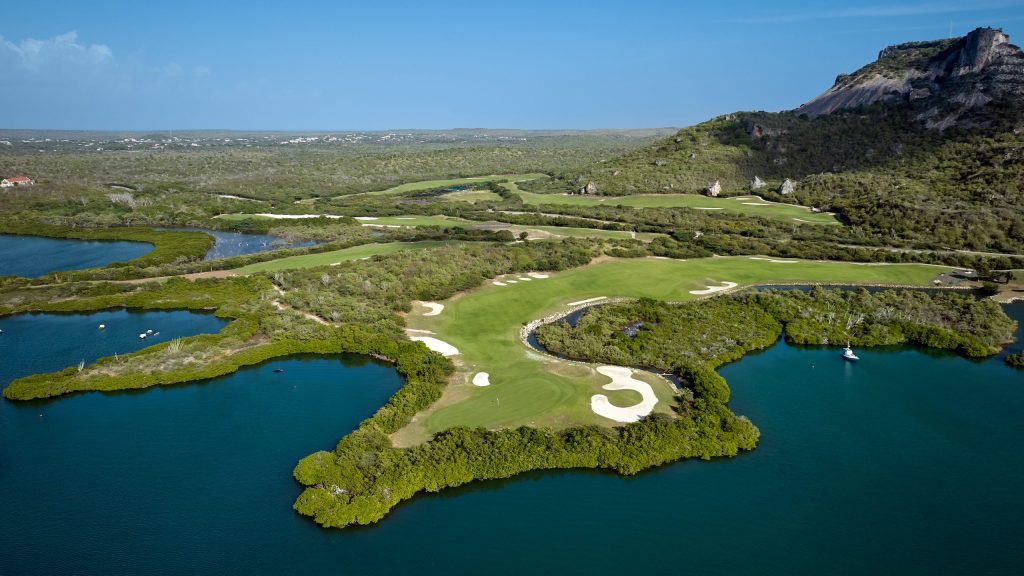 Aerial view of Hole 8 surrounded by water, with Hole 12 and Tafelberg mountain in the background at Old Quarry Curaçao
